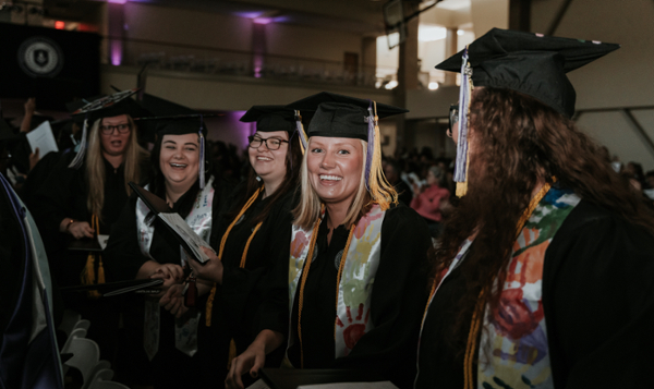 Female graduate with blonde hair sits in the crowd of graduates at MGA's spring 2025 commencement ceremony. 